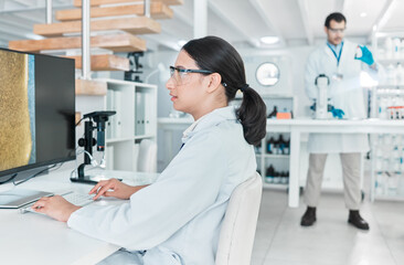 Poster - Constantly questioning, analysing and experimenting. a young scientist working on a computer in a lab.