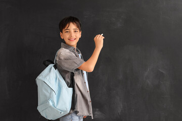 Wall Mural - Little boy with chalk piece drawing on blackboard. Children's Day celebration