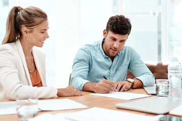 Poster - One signature and its done. two young business colleagues going over some documents in the boardroom.