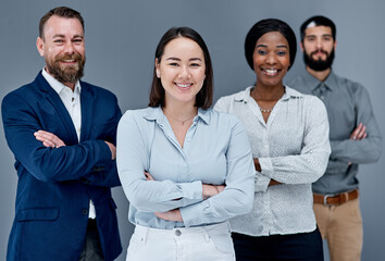 Aufkleber - Effective teamwork brings lots of benefits to our company. Portrait of a group of businesspeople standing together against a grey background.