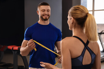 Canvas Print - Trainer having discussion with woman in gym