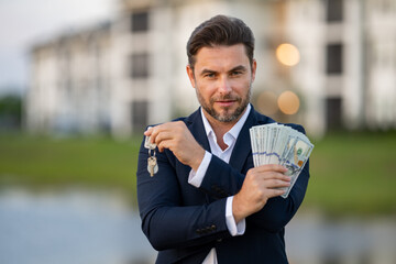 House owner, real estate agents hold money dollars and house keys. Housing estates, buying and selling housing estates. Man celebrating new purchase buying real estate. Mortgage concept.