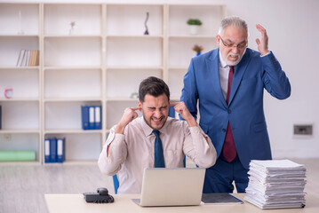 Canvas Print - Old male boss and young male employee in bullying concept