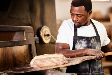 Sticker - My love for baking is why I started this business. a male baker removing freshly baked bread from the oven.