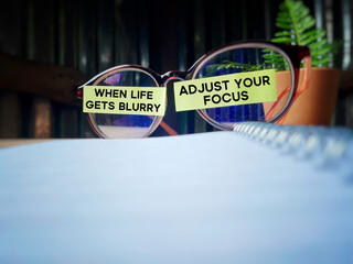 Inspirational and motivational quote. When life gets blurry, adjust your focus. Text written on notepaper background.