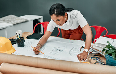 Poster - Working on a new design. a young architect working with blueprints in an office.