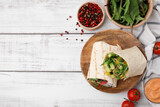 Fototapeta Kawa jest smaczna - Delicious sandwich wraps with fresh vegetables, tomatoes, sauce and peppercorns on white wooden table, flat lay. Space for text