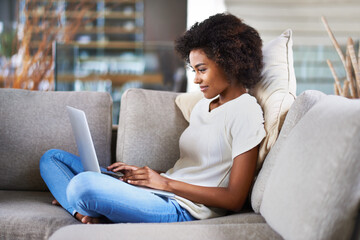 Relax, typing and woman on a couch, laptop and search website at home, happiness and network. Female person, model in a lounge and lady with technology, chilling and online reading on weekend break