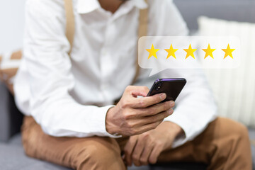 Customer pressing on smartphone with five star icon for feedback review satisfaction service	