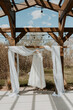 Wedding Dress hanging from the ceremony arbour in spring