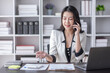 © David - Cheerful business Asian woman freelancer making telephone call share good news about project working in office workplace, business finance concept.