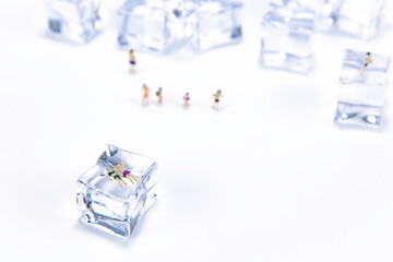 Miniature people in swimsuit resting on ice cube. Summer holiday. anti hot temp concept. isolate white background.