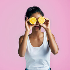 Sticker - I can Vitamin C you. Studio shot of a beautiful young woman posing with oranges over her eyes against a pink background.