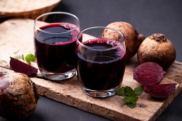 Wall Mural - Fresh beetroot juice in glass on wooden with black background, Healthy drink