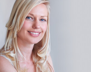 Canvas Print - Natural beauty. A gorgeous blonde woman smiling while isolated on a grey background.