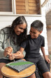 © Austockphoto - Aboriginal girl and boy dot painting together