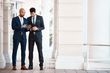 Even on a break they trying to improve business. young handsome businessmen using a cellphone together outside.