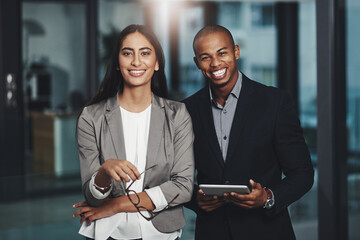 Dedication lies at our core. Portrait of two young businesspeople standing together in an office.