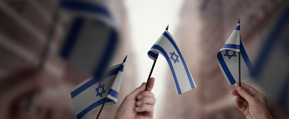 Wall Mural - A group of people holding small flags of the Israel in their hands