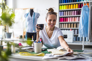 Wall Mural - Young fashion designer at her workplace
