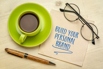Wall Mural - Build your personal brand motivational advice - handwriting on a napkin with a cup of coffee, business and personal development concept