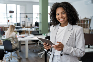 young business woman using touchscreen pc tablet standing in modern office. african american female 