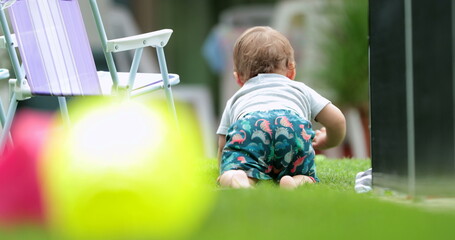 Wall Mural - Adorable baby crawling outside in backyard. Cute toddler child barefoot