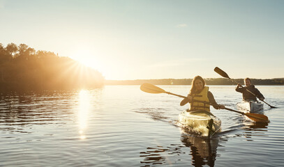 Wall Mural - Out on the water where we love to be. a young couple kayaking on a lake outdoors.