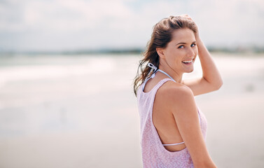 Wall Mural - Loving the fresh air. Portrait of an attractive woman enjoying a day at the beach.