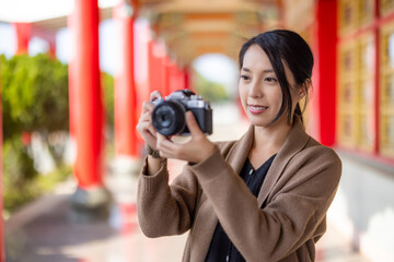 Wall Mural - Travel woman use digital camera to take photo in chinese temple