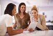 © Hova/peopleimages.com - Getting some design inspiration. Three female colleagues having a discussion while gathered around a digital tablet.