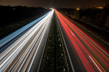 Cars light trails on a straight highway at sunset. Night traffic trails, Motion blur, Night city road with traffic headlight motion.	