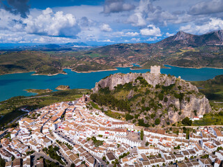 Wall Mural - Picturesque aerial view of Zahara de la Sierra with ancient castle on rocky hill against backdrop of lake, Spain