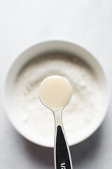 A spoon of condensed milk, condensed milk in a plastic teaspoon