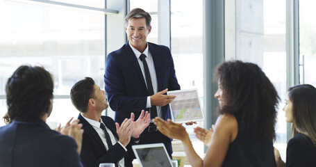 Poster - Applauding his efforts. a businessman using a digital tablet while giving a presentation to his colleagues in an office.