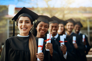 Poster - Becoming the people we dreamt of being. Portrait of a group of young students holding their diplomas on graduation day.