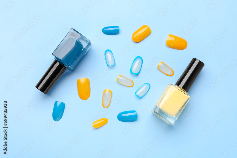 Press-on nails with polishes on blue background