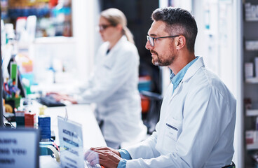 Poster - Everything is digitized in this pharmacy. a mature pharmacist working on a computer in a pharmacy.