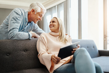 Poster - Happy couples share everything. a mature couple using a digital tablet on the sofa at home.