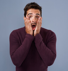Poster - That was totally unexpected. Studio shot of a handsome young man looking surprised against a gray background.