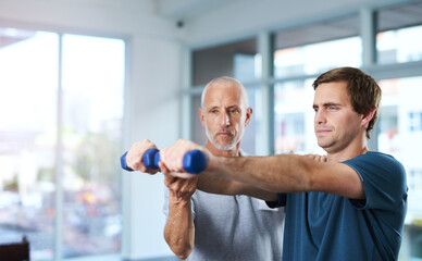 Poster - Working on joint mobility. a handsome mature male physiotherapist helping a patient work through his recovery with weights.