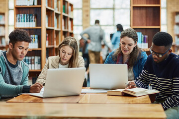 Poster - Staying fully engaged in their education. a group of university students working in the library at campus.