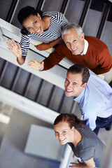 Poster - We welcome you. a group of colleagues standing on a staircase.