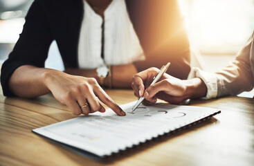 Poster - This is where success lies. Closeup shot of two businesswomen going through paperwork in an office.