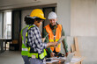 © Nuttapong punna - Engineer teams meeting working together wear worker helmets hardhat on construction site in city. industry professional team.
