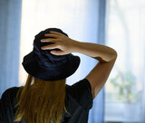 Fototapeta  - Kobieta w kapeluszu z ręką na głowie 