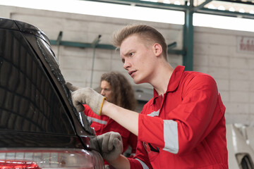 Group of male car mechanic repair rear window of car in auto repair shop. Team of technician checking broken damaged of rear window of car in garage workshop