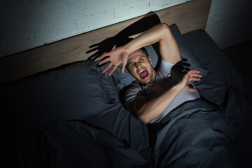 Poster - top view of stressed man screaming while having nightmares and panic attacks at night.