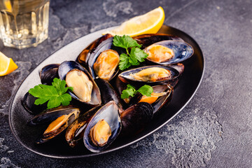 Wall Mural - Delicious seafood mussels with sauce and parsley.