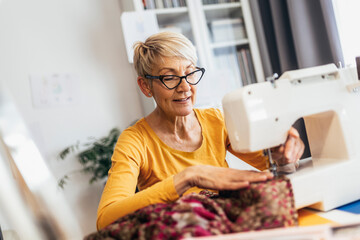 Senior woman sewing at home. Startup small business designer, service.